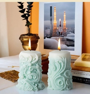 Primer plano de velas cilíndricas verde menta con patrón de relieve en espiral elegante