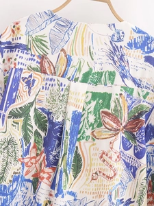 Detail view of the back yoke and pleat on a white blouse with abstract floral patterns