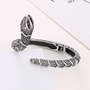 Detail of vintage snake bangle featuring scale texture and spring hinge mechanism
