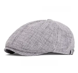 Detail of grey six-panel newsboy cap showing breathable linen texture and side buckle