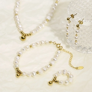 Détail d'un ensemble de bijoux en perles d'eau douce avec perles dorées et étiquette S.STEEL