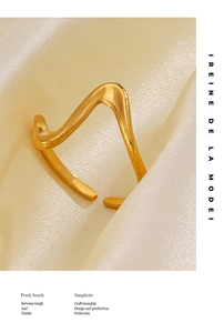 Detailed macro view of gold irregular wavy open ring with brushed matte metal texture