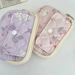 Detailed view of quilted cotton pouches featuring cute floral patterns and snap button pocket