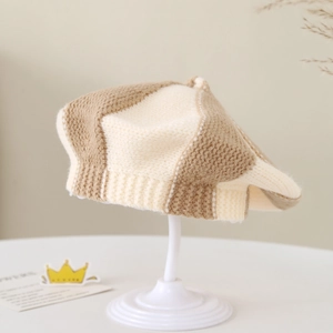 Close-up of knit texture on cream baby beret with a stylish color-block design