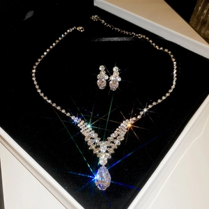 Vue détaillée d'une parure collier et boucles d'oreilles en zircone dans un écrin noir
