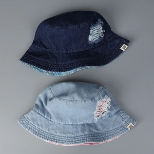 Close-up of distressed denim bucket hats with ripped details and plaid lining