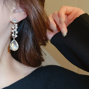 Primo piano di un orecchino a goccia d'argento con cristalli su una modella