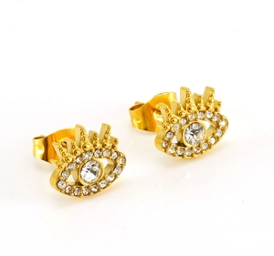 Detail view of golden evil eye stud earrings featuring clear zircon stones and eyelashes