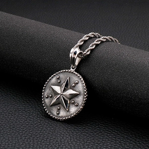 Gros plan du collier en acier titane vintage avec pendentif rond pentagramme et chaîne torsadée