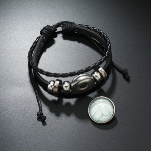 Vue détaillée du bracelet multicouche en cuir noir avec breloque en verre de football