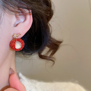 Detailed view of a sweet red apple earring with sparkling zircon leaf and resin center