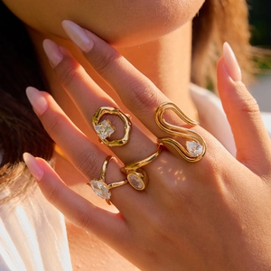 Close-up of elegant gold titanium steel rings with zirconia stones on a model's hand