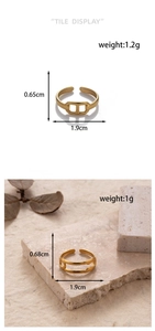 Detailed view of adjustable golden snake-style and chain link rings on a stone surface