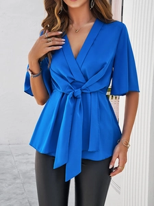 Détail du haut bleu à col en V avec taille nouée et manches courtes sur mannequin