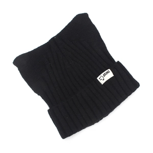 Détail du bonnet en maille noire avec oreilles de chat et étiquette tissée blanche