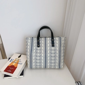 Floral canvas tote bag with blue lace pattern and black leather handles for daily use