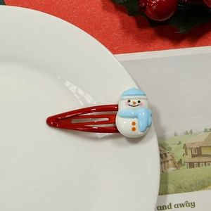 Close-up of a festive red metal hair clip featuring a cute white resin snowman detail