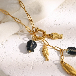 Detail of 18K gold-plated paperclip chain necklace with gold and dark fish charms