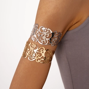 Dettaglio di bracciali da braccio oro e argento con motivi a vite in stile boho