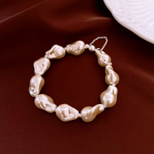 Detailed view of baroque pearls on a satin background with elegant metallic clasp