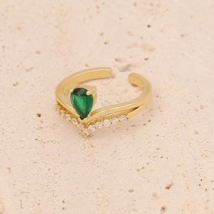 Detailed macro shot of pear-cut emerald green zircon and micro-pave V-shaped golden ring