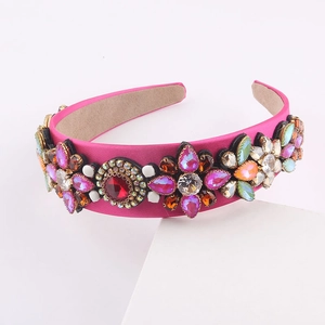 Detail of rose pink satin headband with colorful rhinestones and floral gem patterns