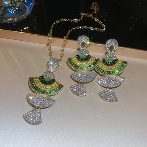Detailed close-up of golden fan-shaped jewelry set with green and yellow rhinestones