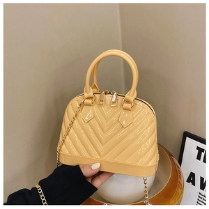 Detail of creamy yellow jelly shell bag featuring V-shaped texture and gold chain