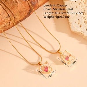 Collier doré en acier inoxydable avec pendentif cœur rose présenté sur pierre chaude