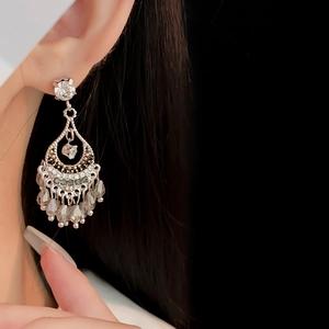 Gros plan de boucles d'oreilles à pompon en argent avec zircon porté sur le mannequin