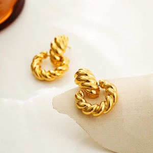 Dettaglio macro di orecchini in oro 18K con design a corda intrecciata vintage