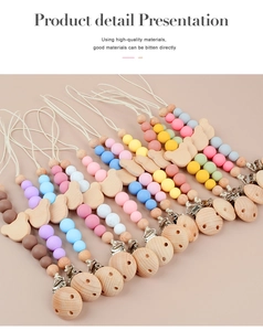 Flat lay of colorful baby pacifier clips featuring wooden bears and silicone beads