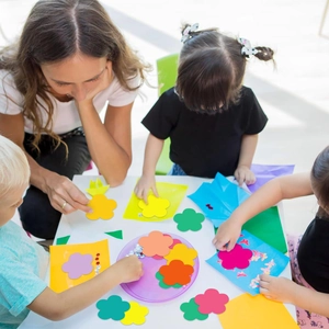 Children creating DIY paper flower cutouts for classroom and school bulletin boards