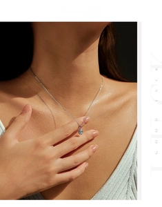 Gros plan d'un collier en argent S925 avec pendentif en moissanite bleue sur le cou