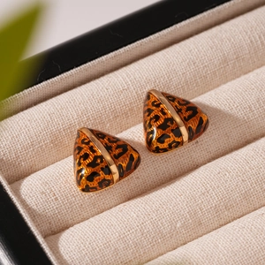 Macro shot of triangle leopard print earrings with gold plating in a jewelry box