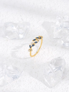 Macro shot of gold leaf ring with marquise blue stones and white zircon details
