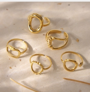 Flat lay of five geometric 18K gold plated rings with various textured patterns