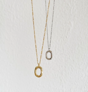 Detail showing S925 stamp on minimalist hammered gold and silver donut pendant necklaces