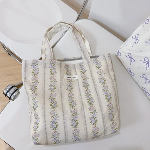 Close-up of floral floral patterns and 'simple wish' label on a beige canvas tote bag