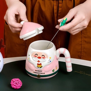 Pink ceramic Santa mug detail with Merry Christmas print and festive tree mixing spoon
