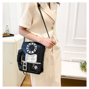 Close-up of creative vintage phone-shaped crossbody bag with dial details and handset