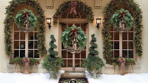 Close-up of rustic Christmas wreath with metal bells, pine cones and warm LED lights
