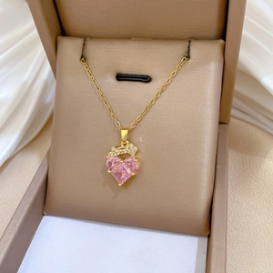 Macro shot of pink heart-shaped zircon pendant in gold-plated necklace gift box