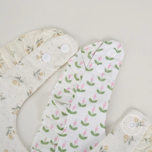 Floral cotton muslin baby bibs with adjustable snap buttons and ruffle edge detail