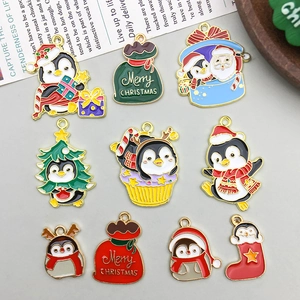 Detailed view of 10 assorted Christmas penguin and Santa alloy charms with gold plating