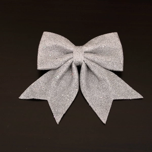 Detail of silver glitter Christmas bow with shimmering texture for festive tree decoration