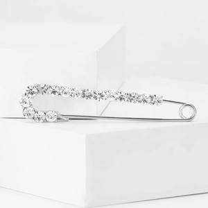 Elegant silver alloy safety pin brooch with rhinestones on white display pedestals