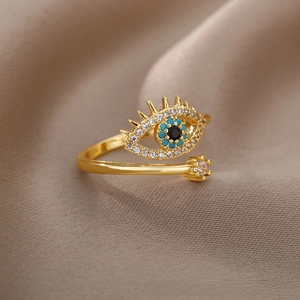 Detailed shot of gold evil eye adjustable ring with blue stones and white crystals