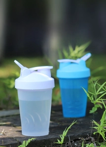 Outdoor close-up of blue and white 400ml shaker bottles for protein shakes and fitness
