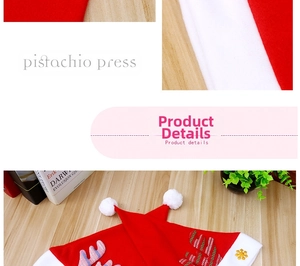 Detail einer roten Plüsch-Weihnachtsmütze mit Pailletten-Rentiergeweih und goldener Schneeflocke